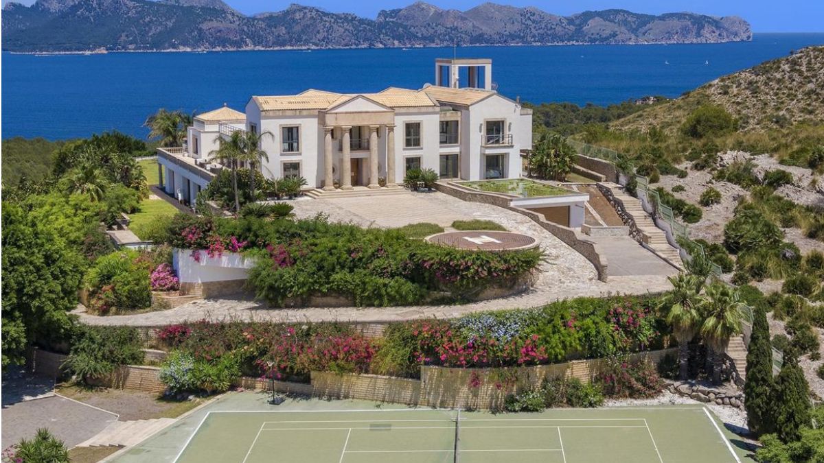 Seaside luxury villa in Mallorca with tennis court in the forefront and seaviews making up the backdrop